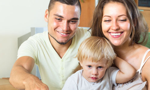 Young family sitting together and smiling.
